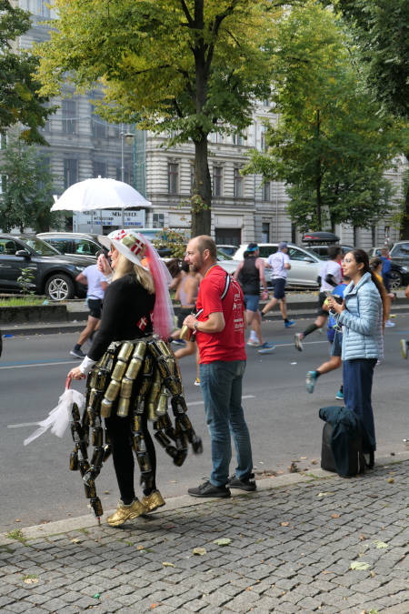 spectator dressed in beer can skirt cheering runners