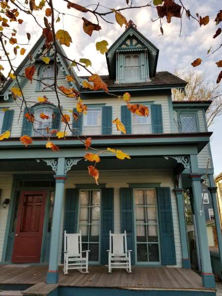 Victorian house with tree having colorful Autumn leaves