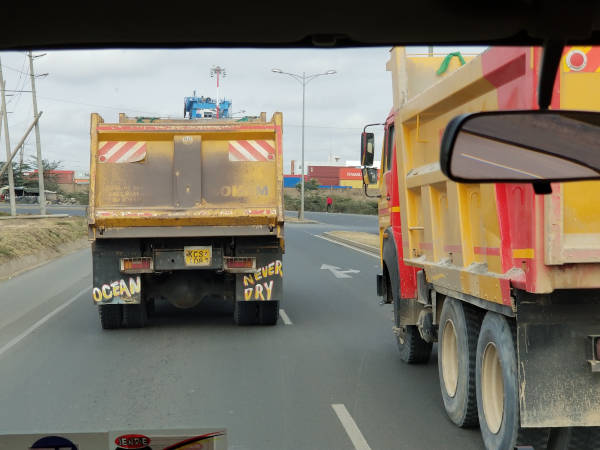 fun trucks on Kenyan road, one with the message Ocean Never Dry